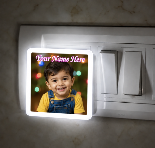Light switch cover with a child's photo and 'Your Name Here' text on a marble surface.